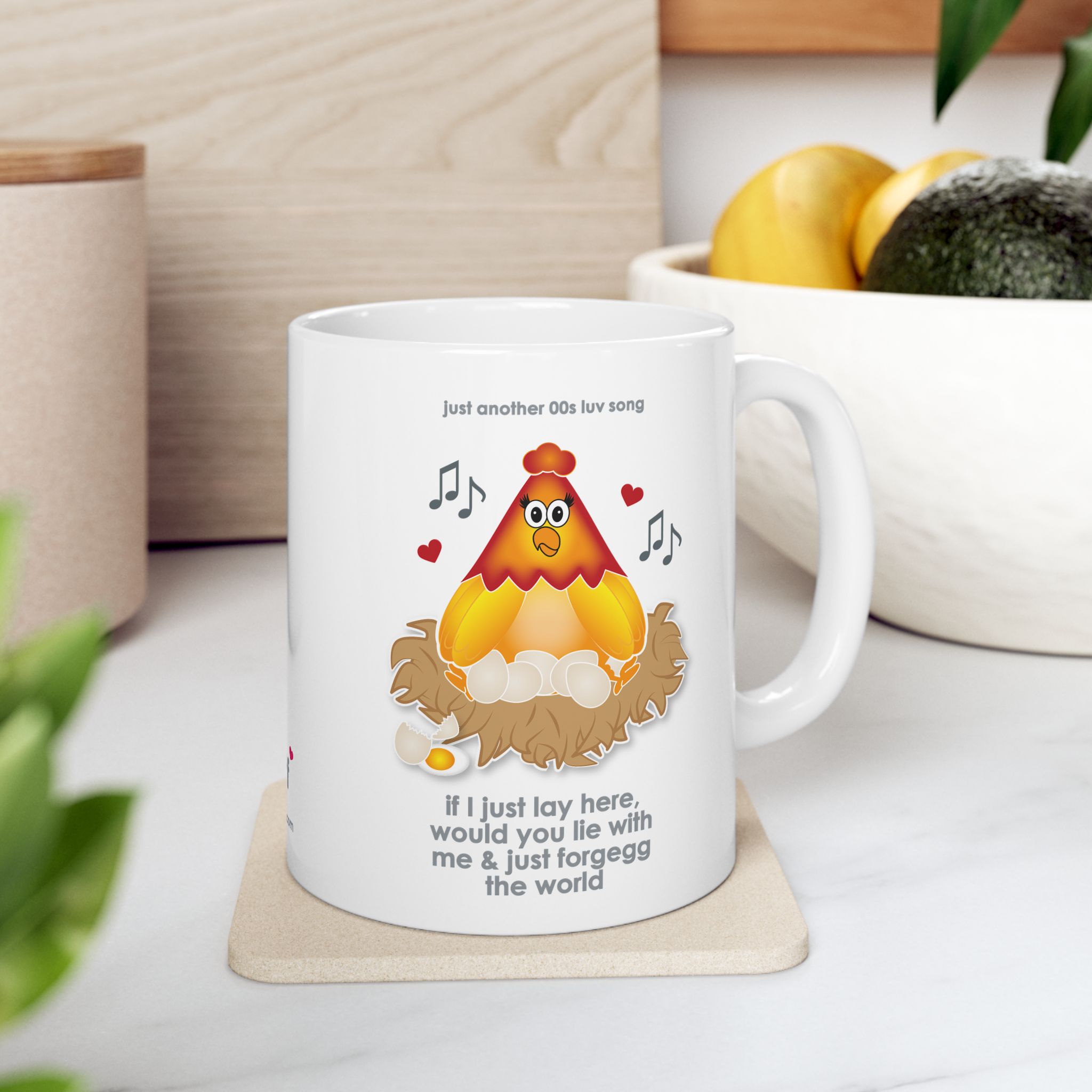 If I Lay Here Mug (11oz, 15oz) 6 White ceramic mug printed with a cartoon chicken on some eggs in a nest, text reads "if I just lay here, would you lie with me & just forgegg the world" in kitchen with fruit bowl