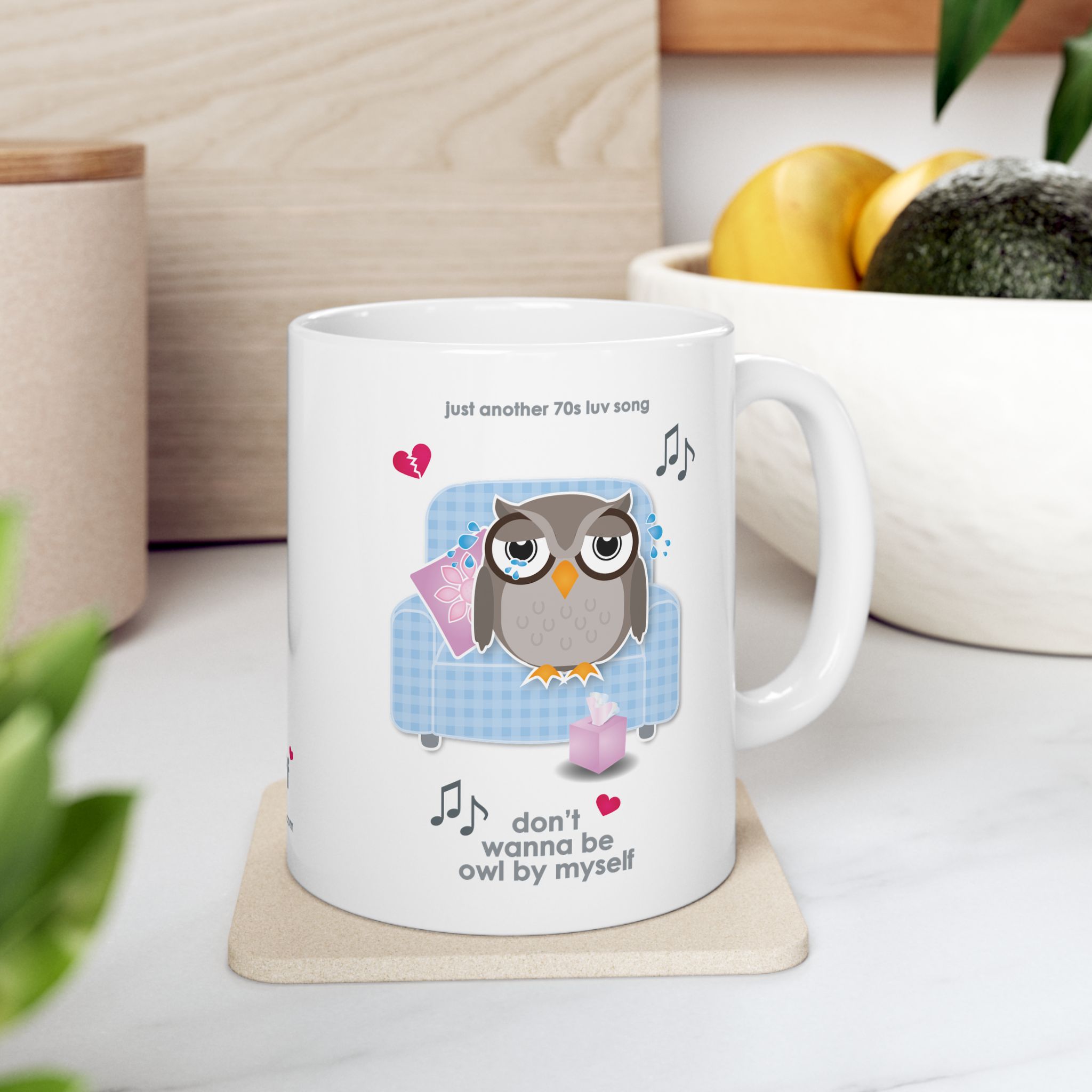 Owl By Myself Love Song Mug (11oz, 15oz) 6 White ceramic Owl By Myself Mug featuring a cartoon owl, crying on a blue chair with a box of tissues, text reads "don't wanna be owl by myself" in kitchen with fruit bowl
