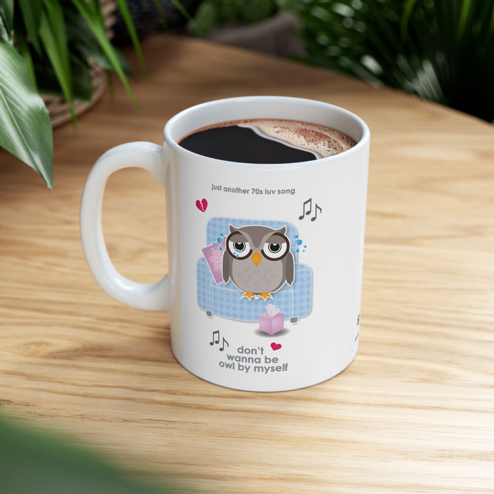 Owl By Myself Love Song Mug (11oz, 15oz) 7 White ceramic Owl By Myself Mug featuring a cartoon owl, crying on a blue chair with a box of tissues, text reads "don't wanna be owl by myself" on wooden table