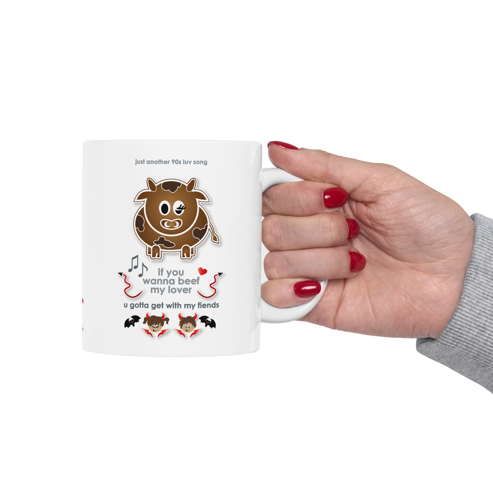Beef My Lover Love Song Mug (11oz, 15oz) 10 White ceramic Beef my Lover love song mug featuring a cartoon cow, an angel and a fiend, text reads "if you wanna beef my lover, u gotta get with my fiends" held by woman's hand with red nail polish