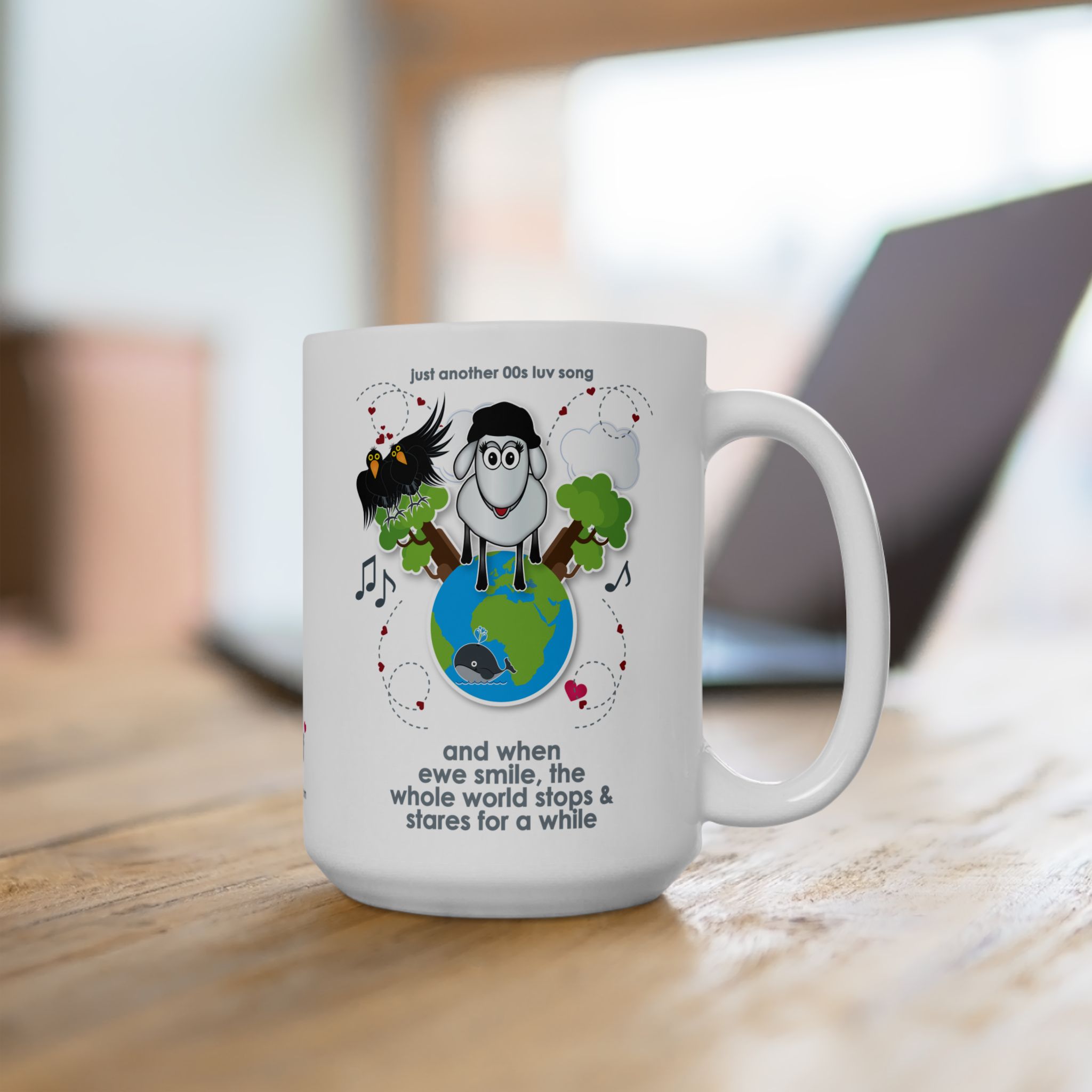 When Ewe Smile Love Song Mug (11oz, 15oz) 14 15oz White ceramic mug printed with a cartoon sheep and some crows on a globe, text reads "and when ewe smile the whole world stops & stares for a while" on wooden desk with laptop