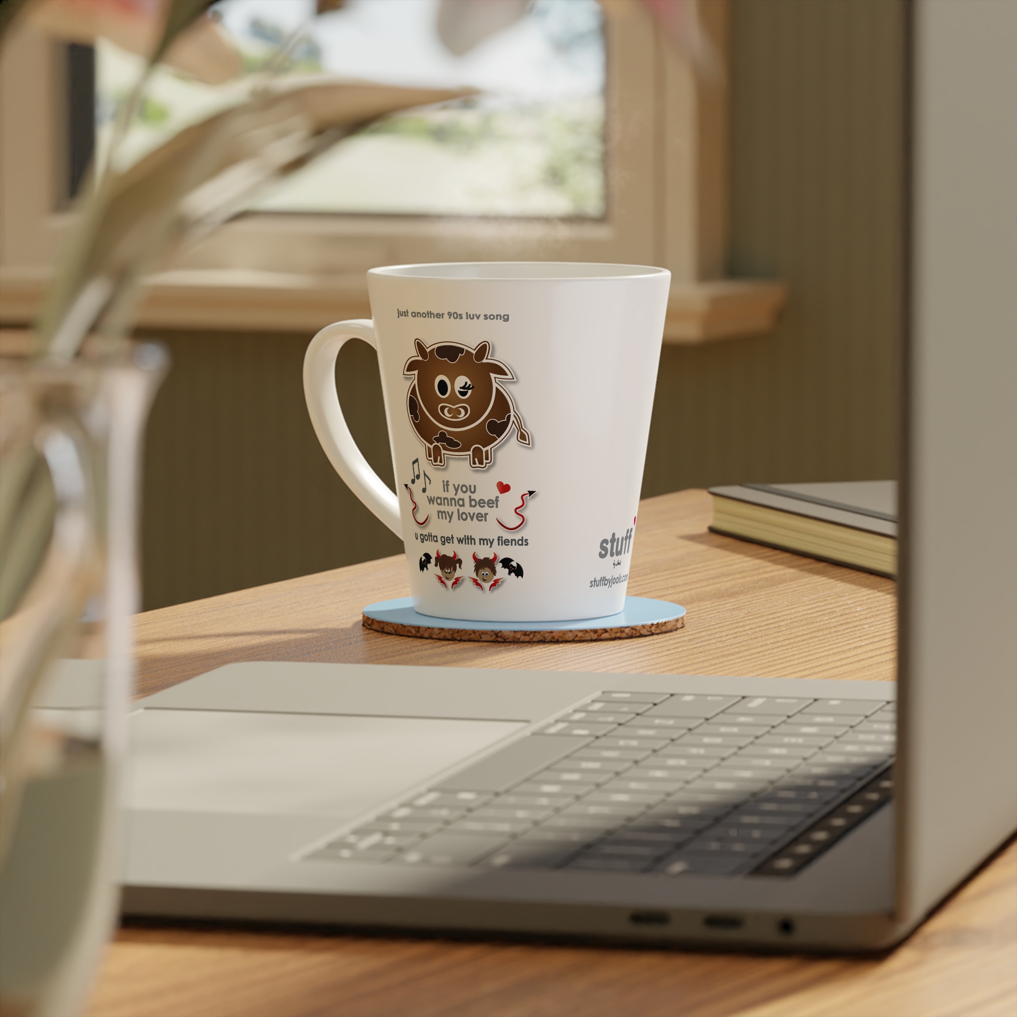 Beef My Lover Love Song Latte Mug 4 White ceramic 12oz Beef my Lover Love Song latte mug, a love song mug featuring a cartoon cow, an angel and a fiend, text reads "if you wanna beef my lover, u gotta get with my fiends" on table with coaster and accessories