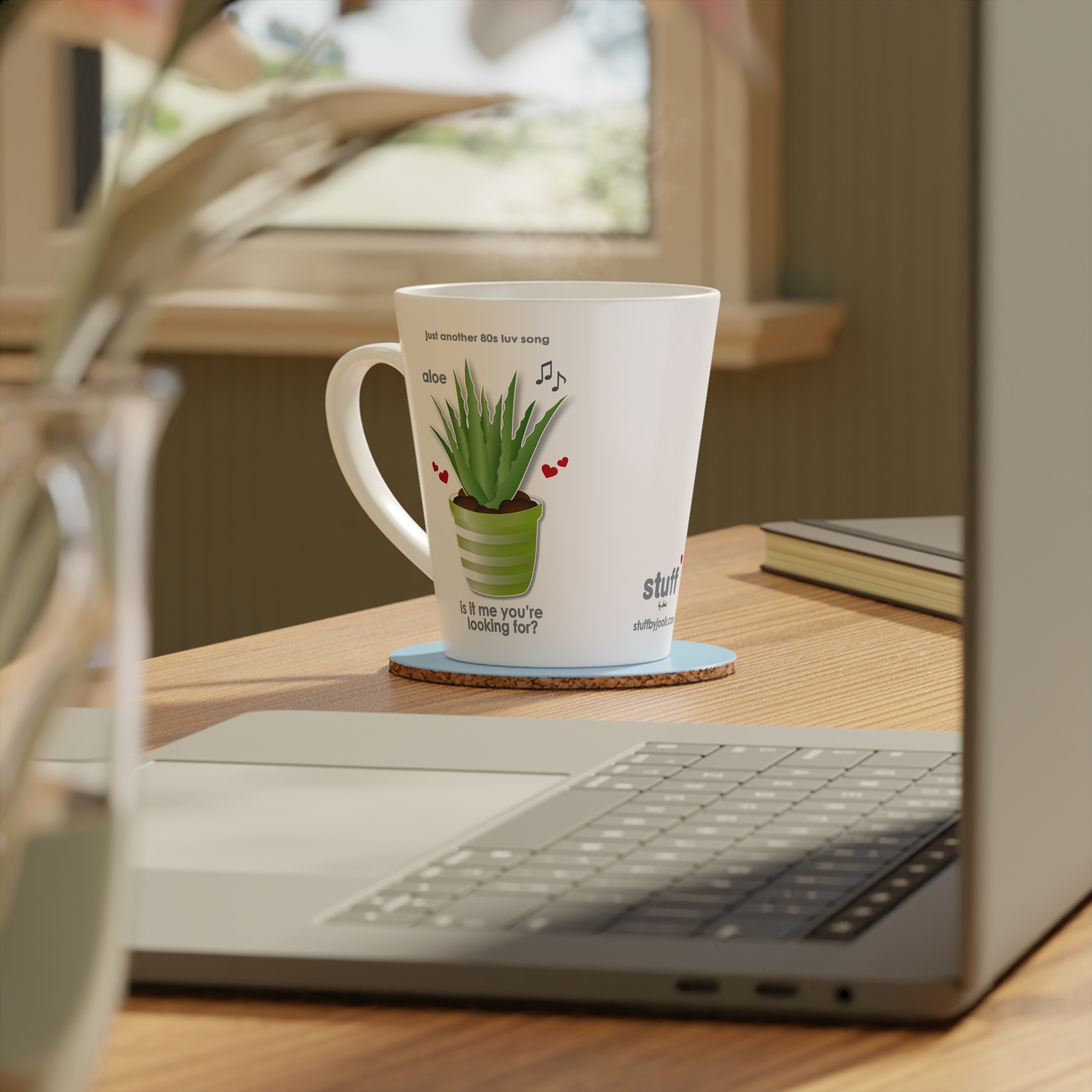 Aloe Is It Me? Love Song Latte Mug 4 12oz Aloe Is It Me? Love Song Latte Mug White ceramic mug right view featuring a potted aloe, hearts and musical notes, text reads "aloe is it me you're looking for" on table with coaster and accessories